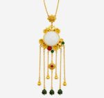 Imperial Radiance Necklace with large white jade center, gold floral frame, and multi-strand golden tassels