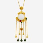 Imperial Radiance Necklace with large white jade center, gold floral frame, and multi-strand golden tassels